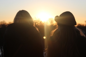 Silhouettes of two girls in front of sunset.